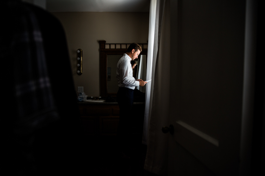 Groom reading letter by window at a Florida wedding venue