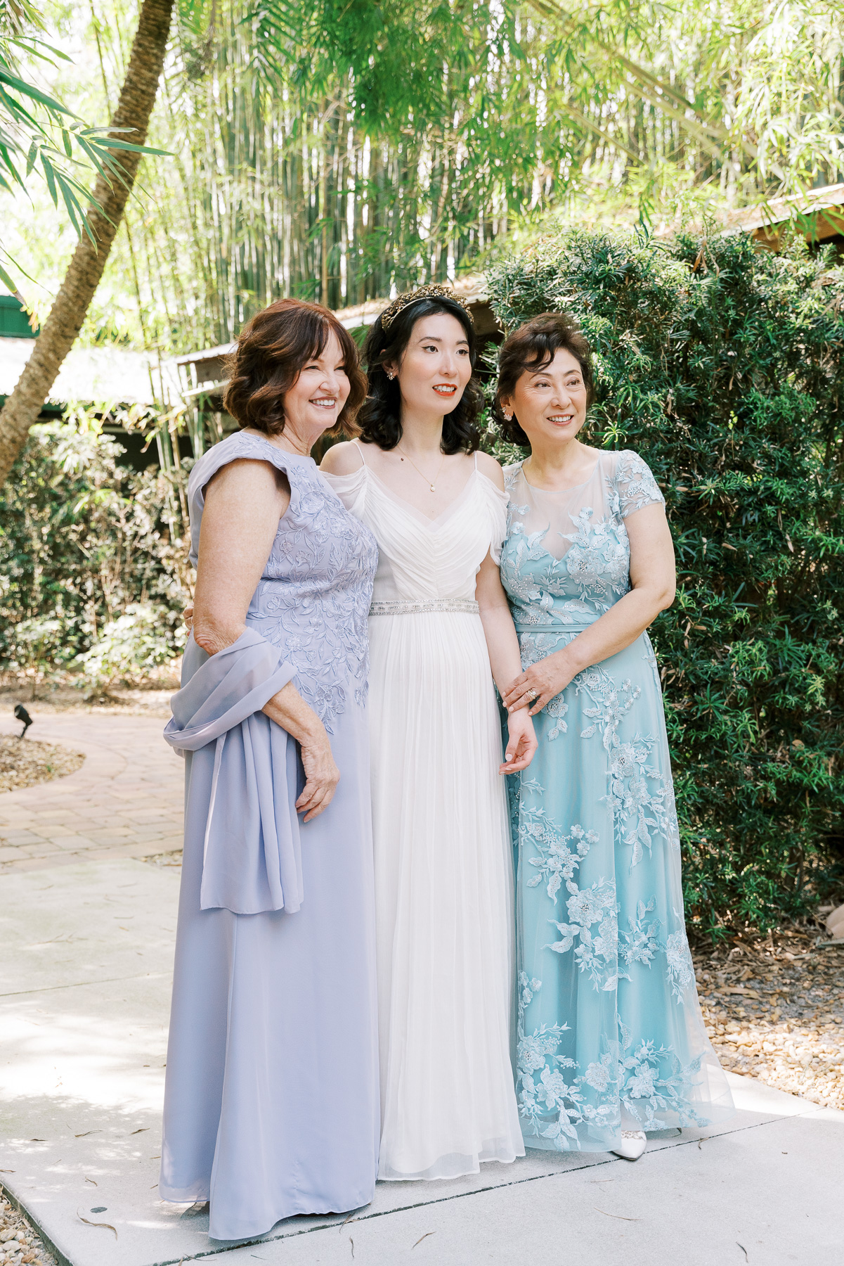 Bride poses for a photo next to women in formal dresses for a wedding