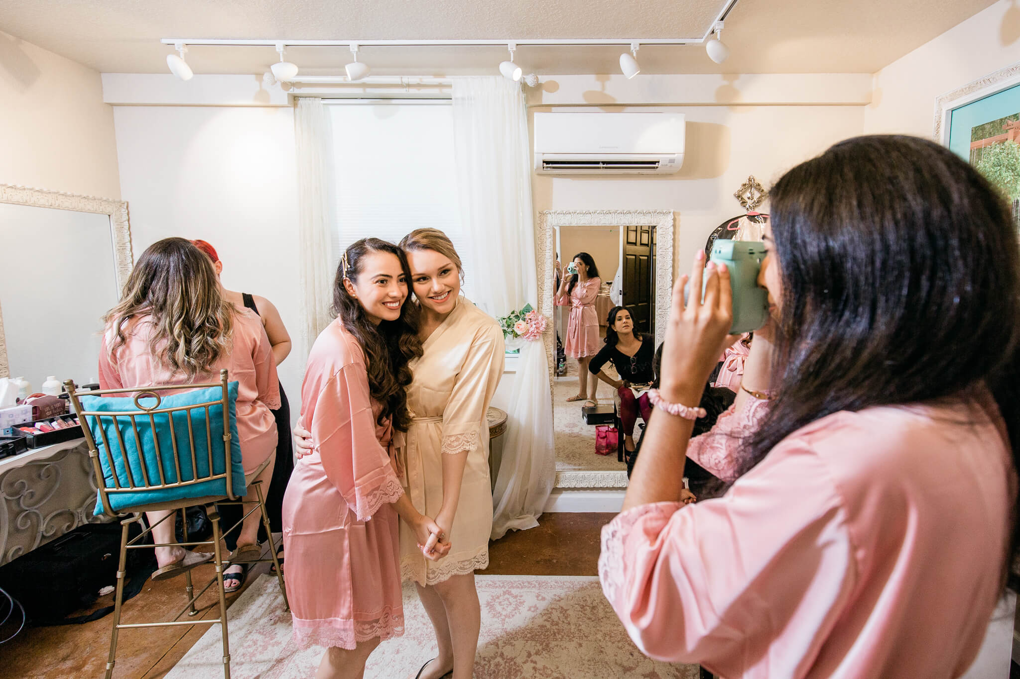 bride and bridesmaids in silk robes get ready in bridal suite at Bakers Ranch