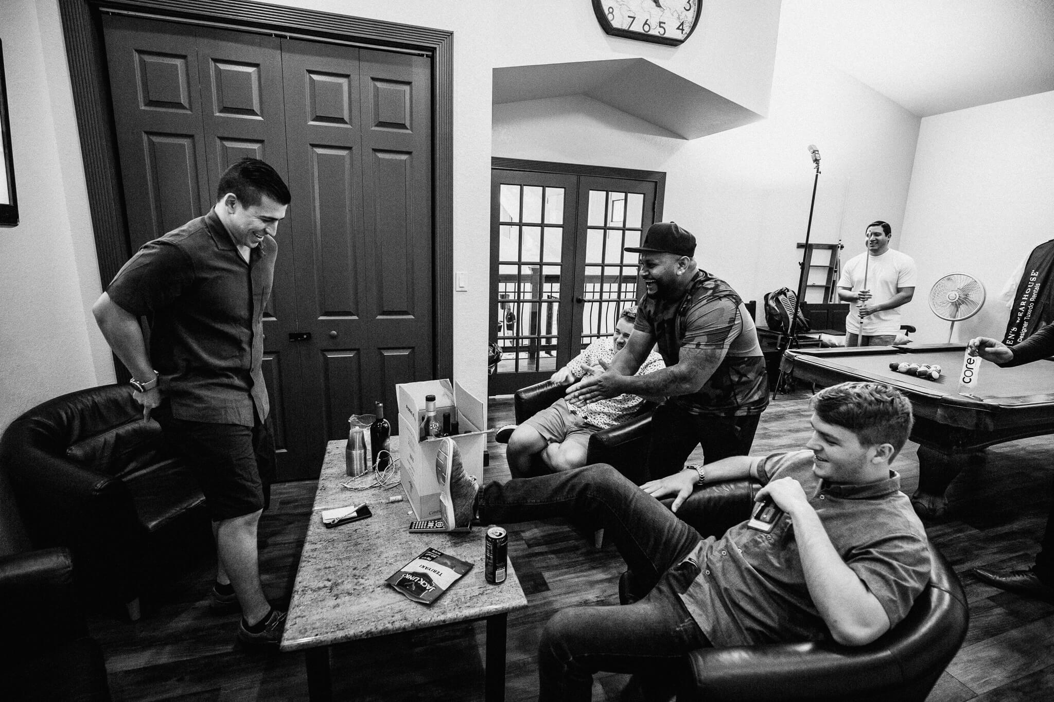 groom and groomsmen relax in getting-ready room at Bakers Ranch wedding venue