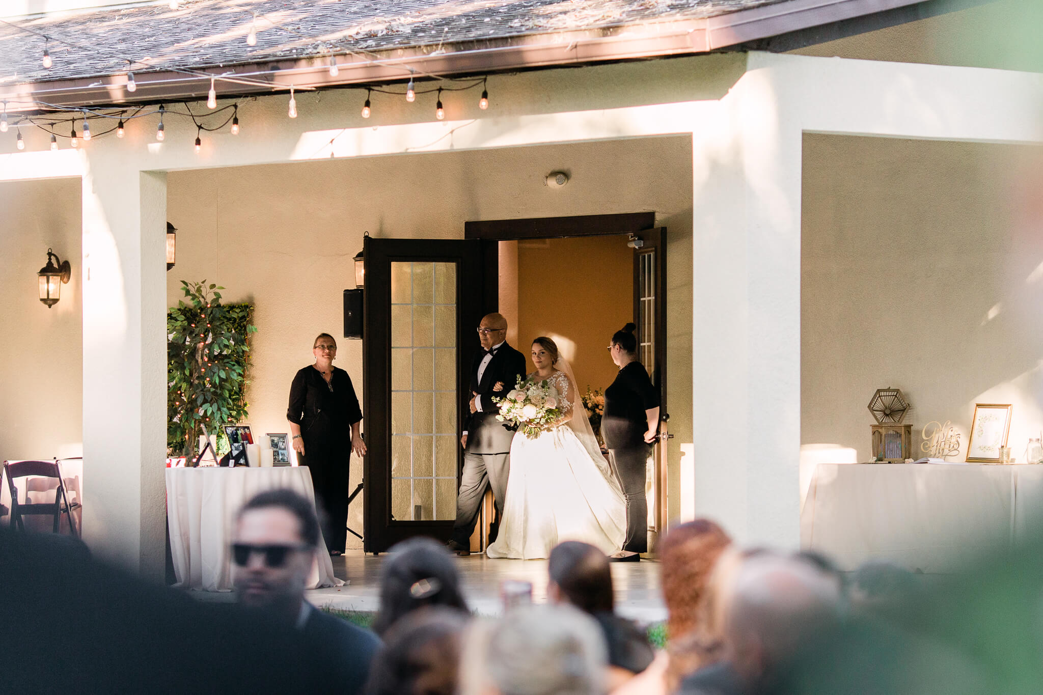bride escorted by father come out of building