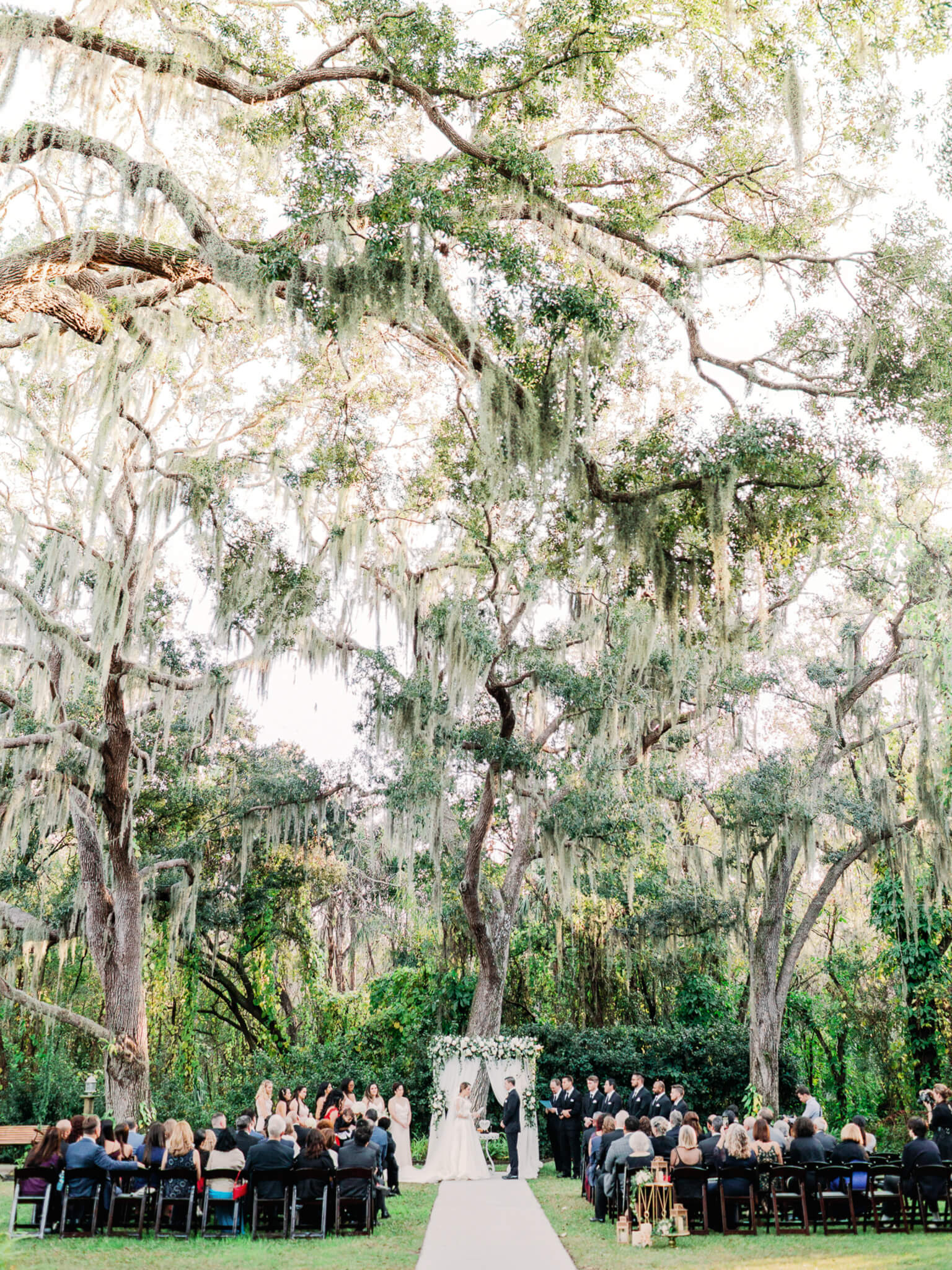 outdoor wedding ceremony in lush garden with tall trees at Bakers Ranch wedding venue
