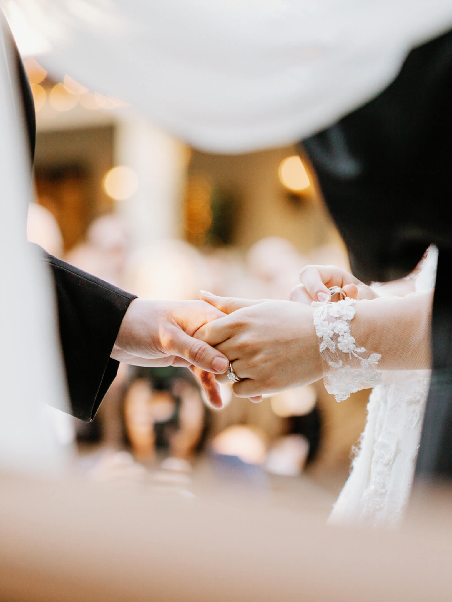 close up of bride and groom's hands exchanging wedding rings