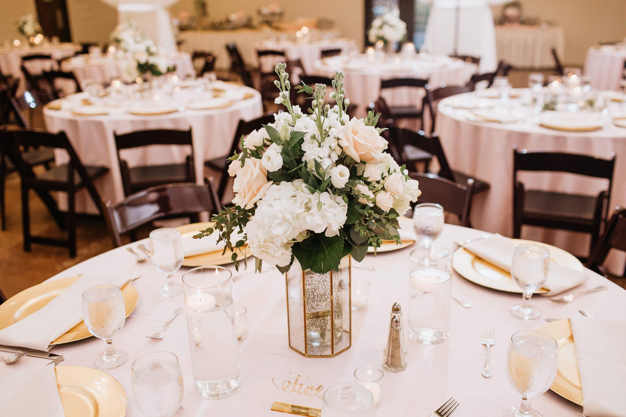 a flower centerpiece on a table at a reception venue