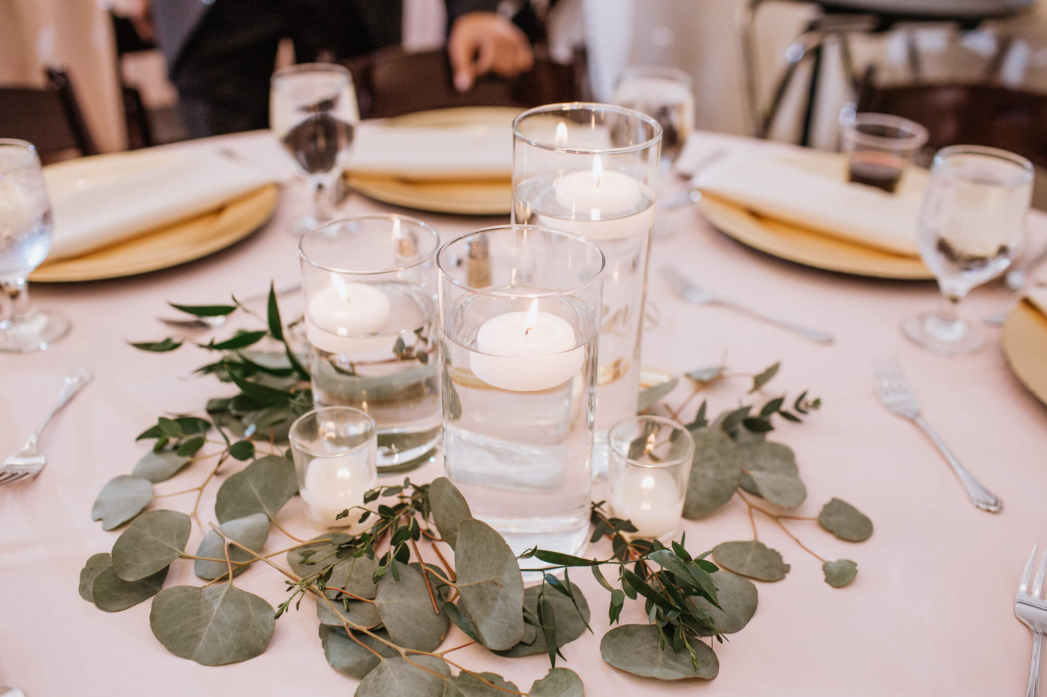 centerpiece with glass vases holding water and floating candles