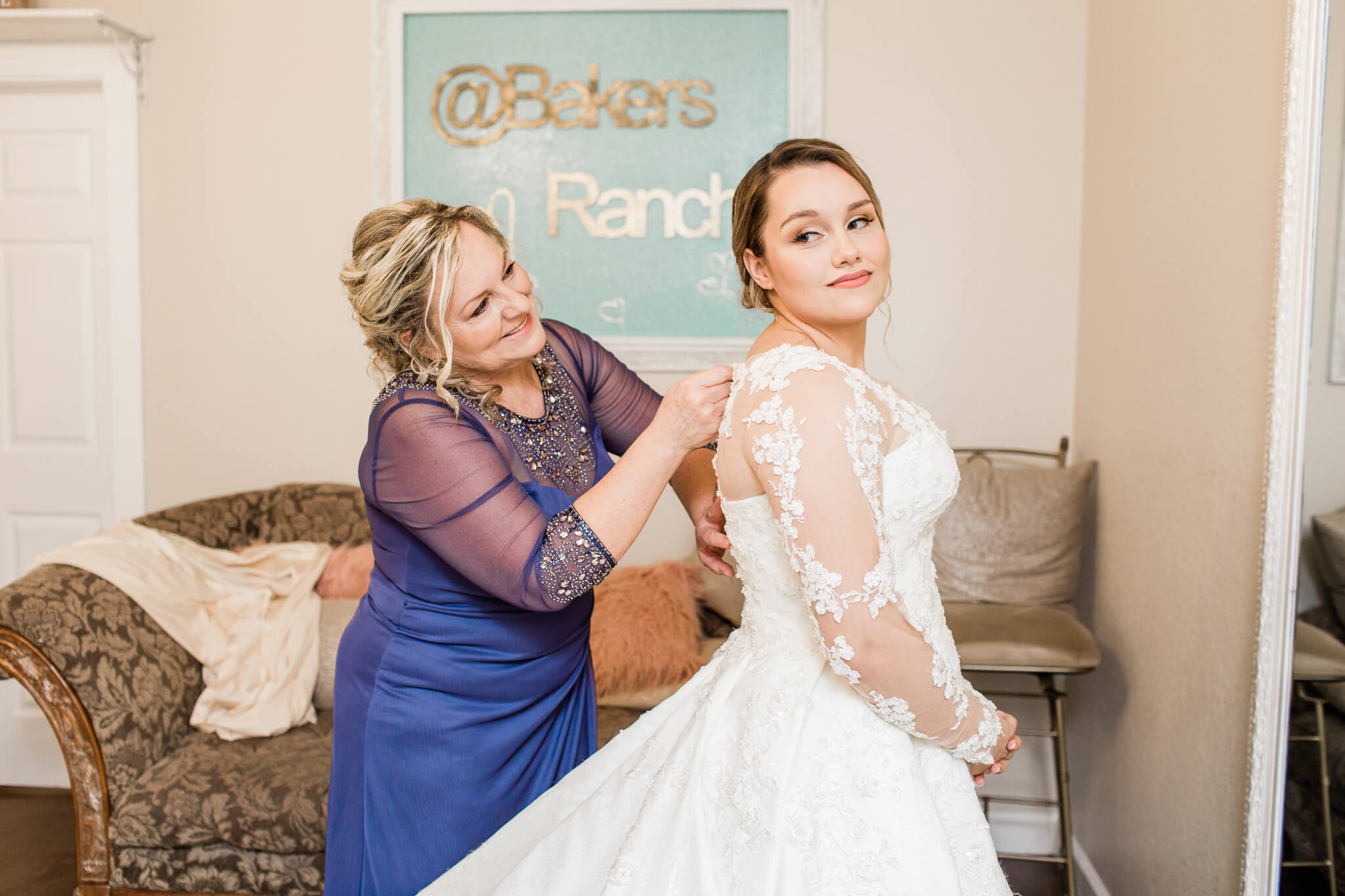 mother of the bride adjusts the bride's wedding dress at Bakers Ranch bridal suite