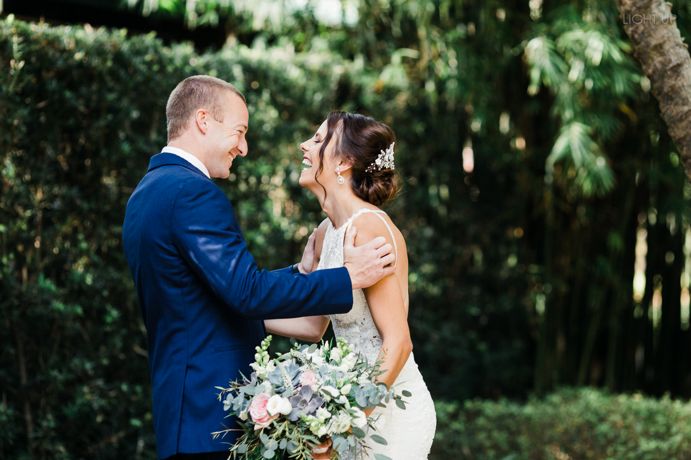 Groom reacts to seeing bride during first look in a lush garden at a Florida Wedding Venue