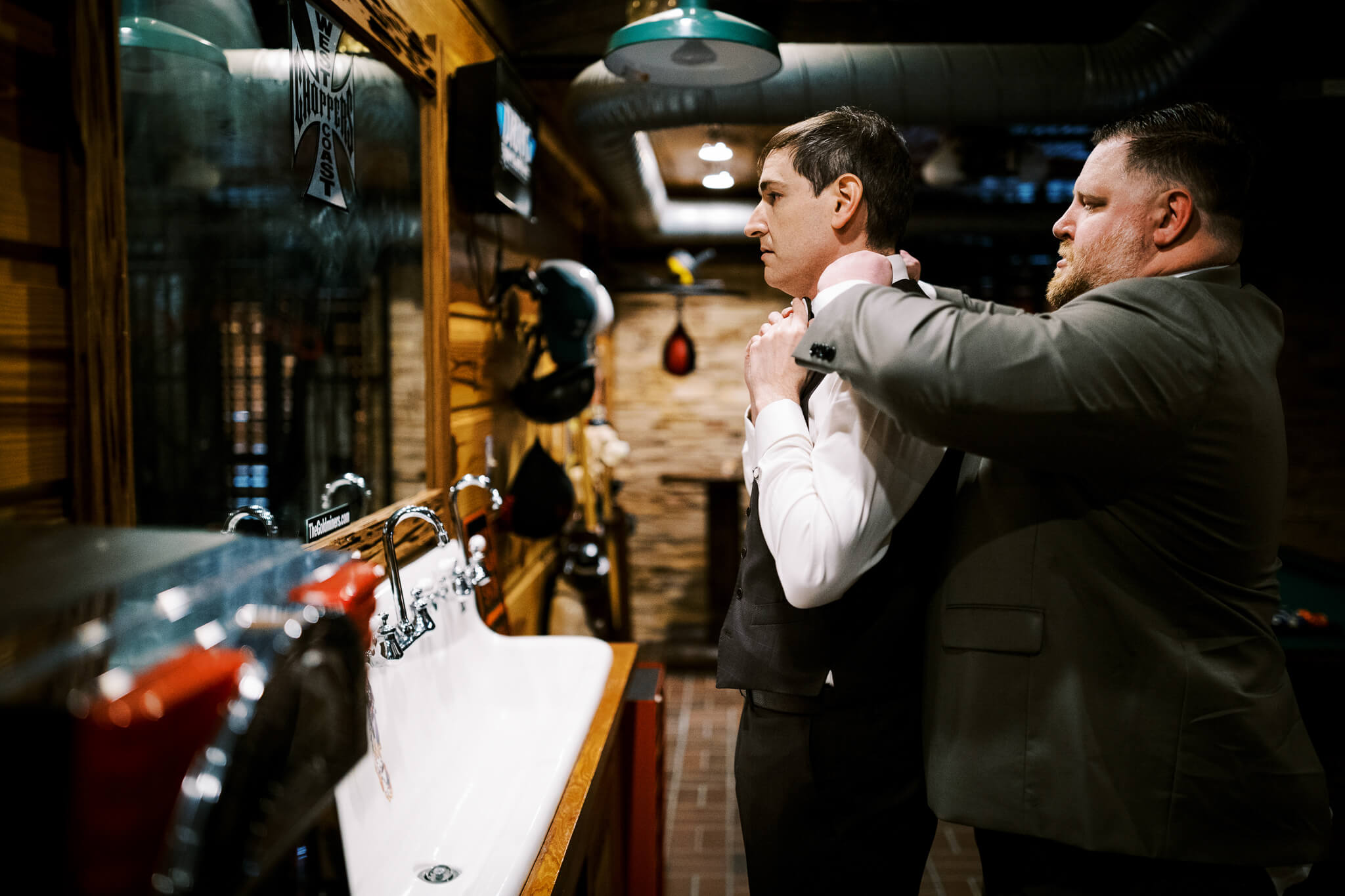 Best man helps groom with his jacket at an outdoor wedding venue in Orlando