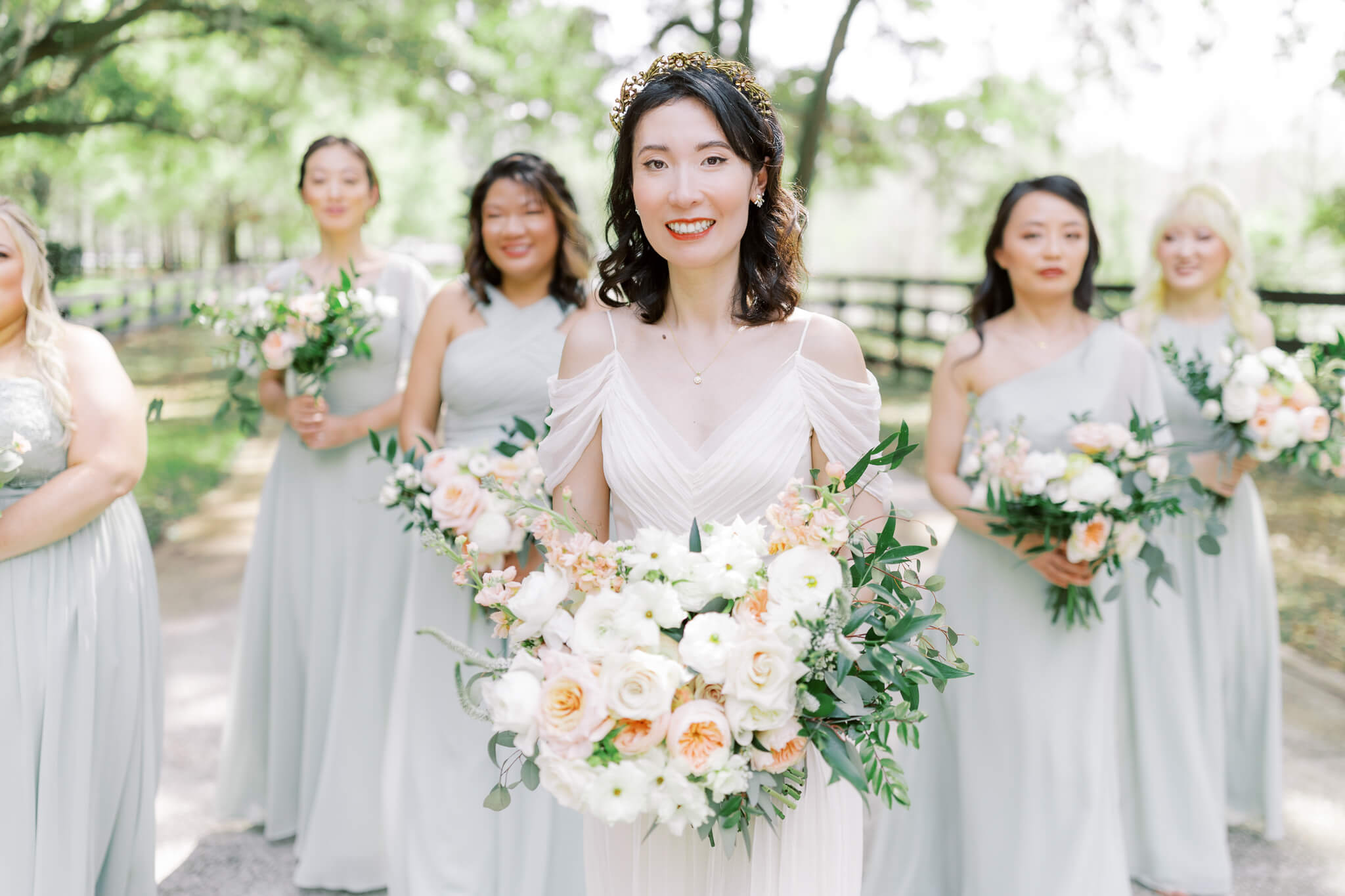 Group of bridesmaids holding wedding bouquets and smiling at an outdoor wedding venue in Central FL