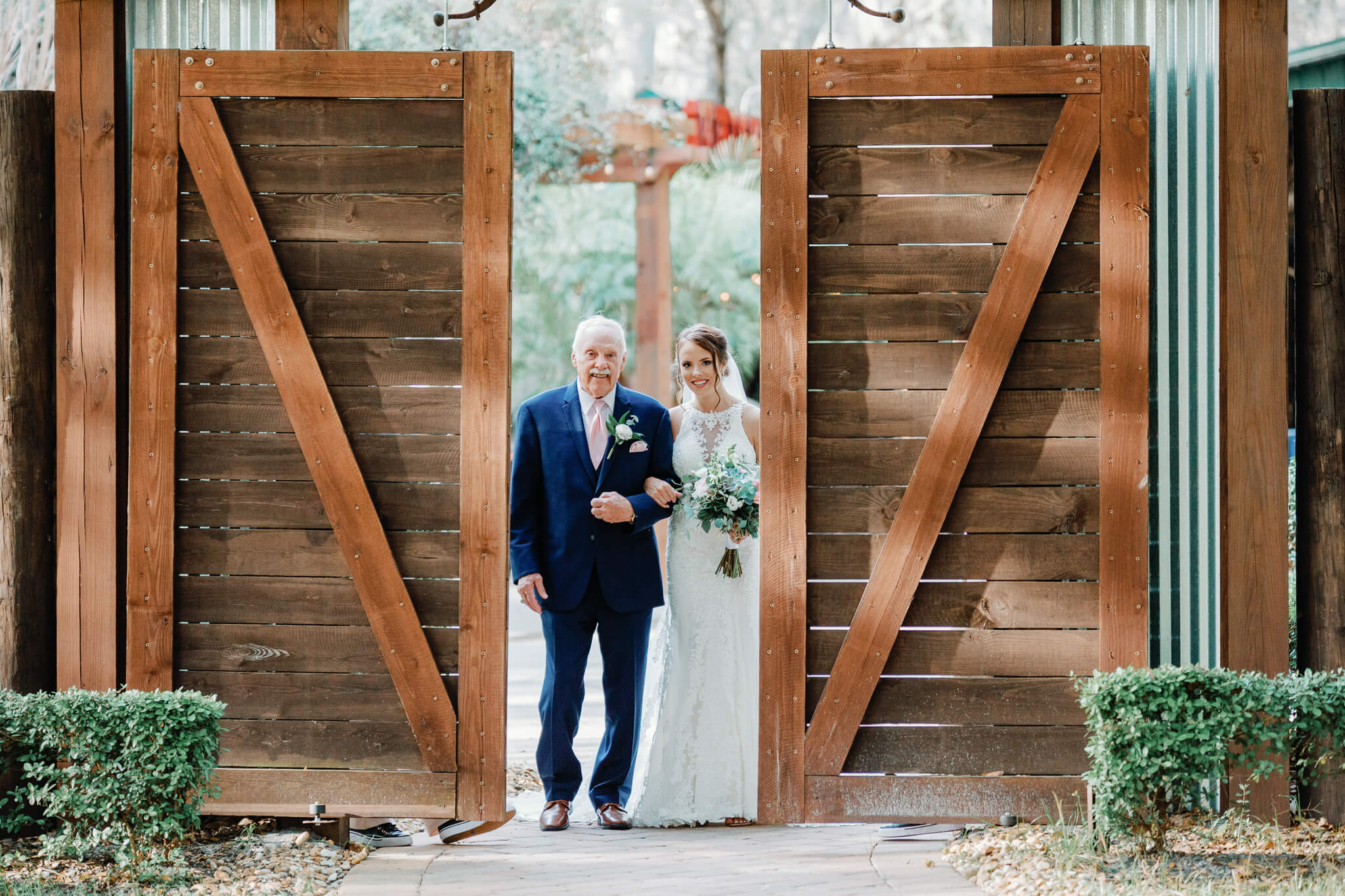 barn doors opening and revealing the entrance of the bride holding her dad's arm