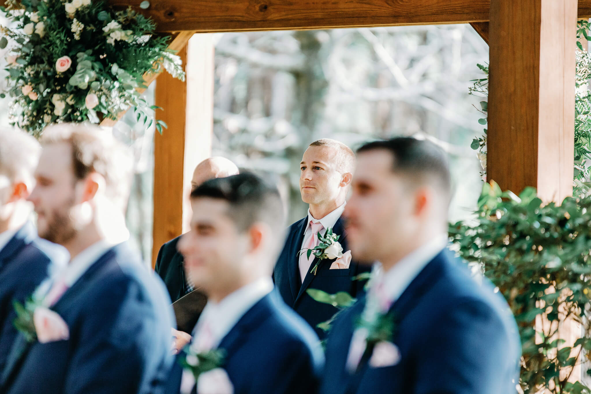 Groom in blue suit sees bride coming down the isle at an outdoor wedding venue in Central FL