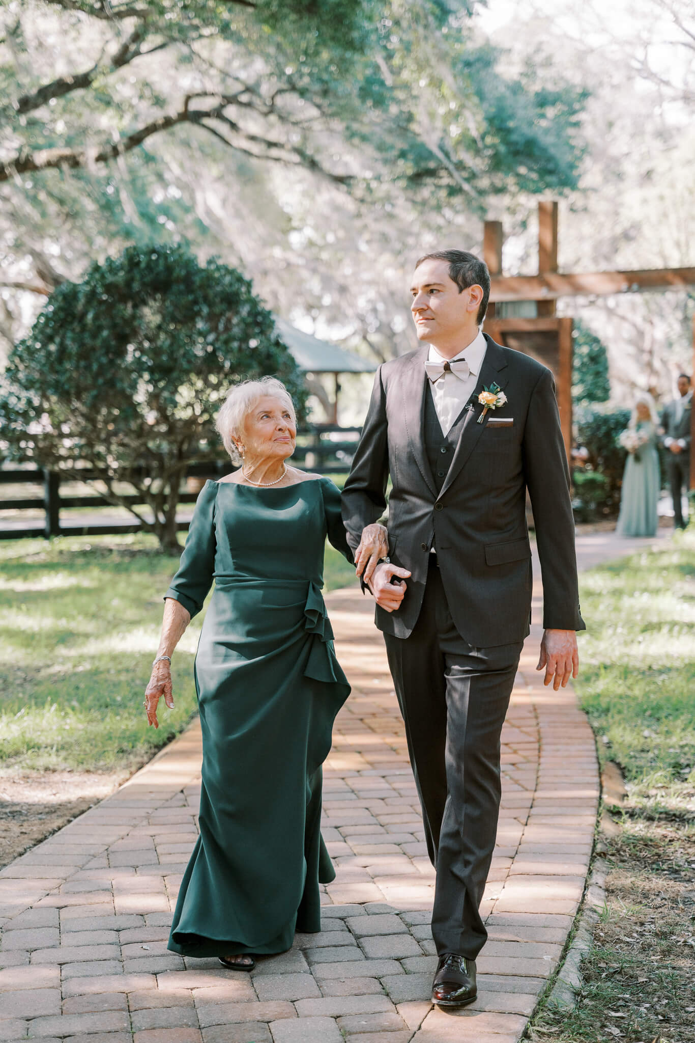 Groom walks grandmother as she holds his arm at an outdoor wedding venue in Central FL