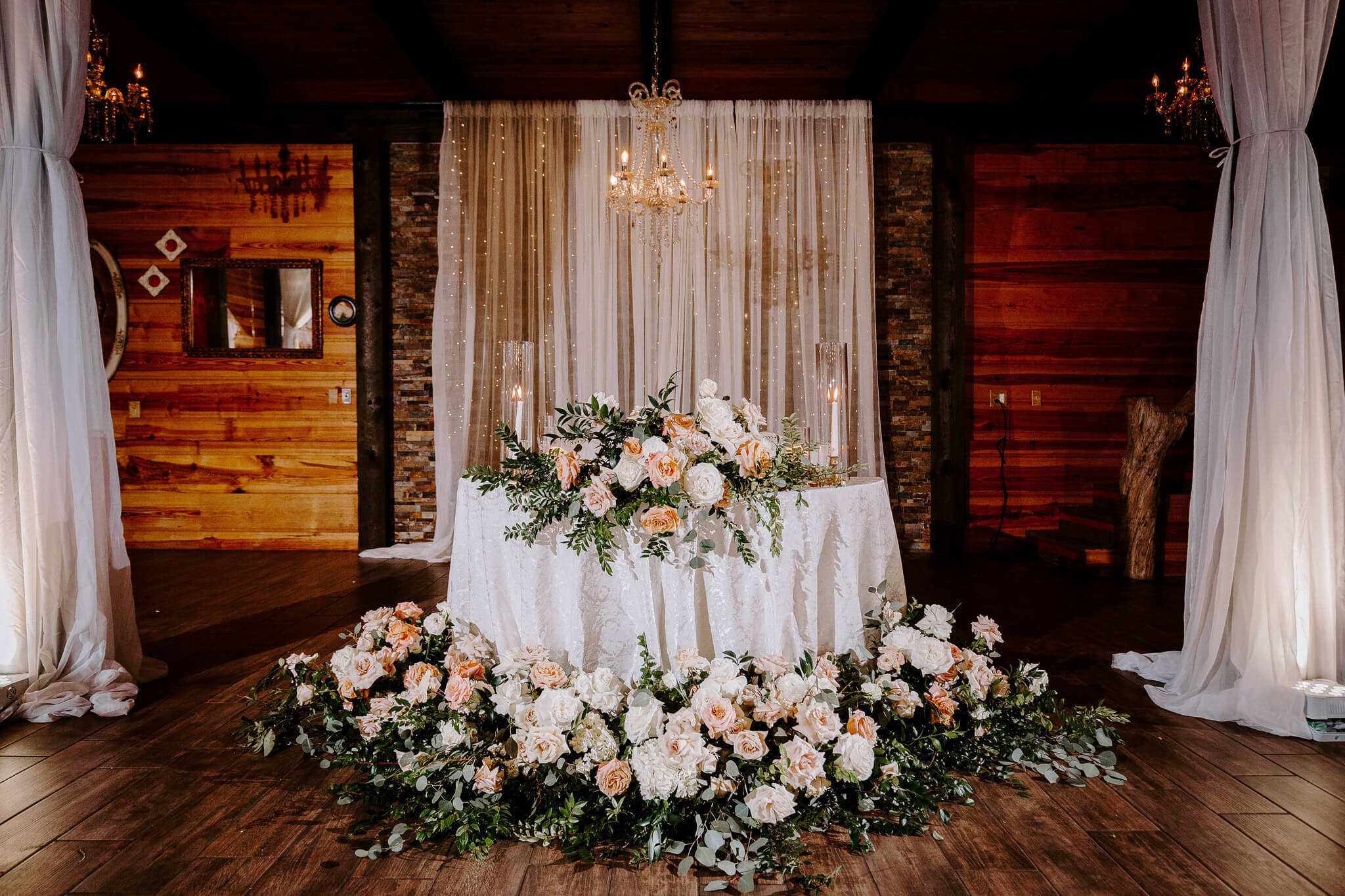 Sweetheart table with large flower arrangement at a wedding at an outdoor wedding venue in Central FL