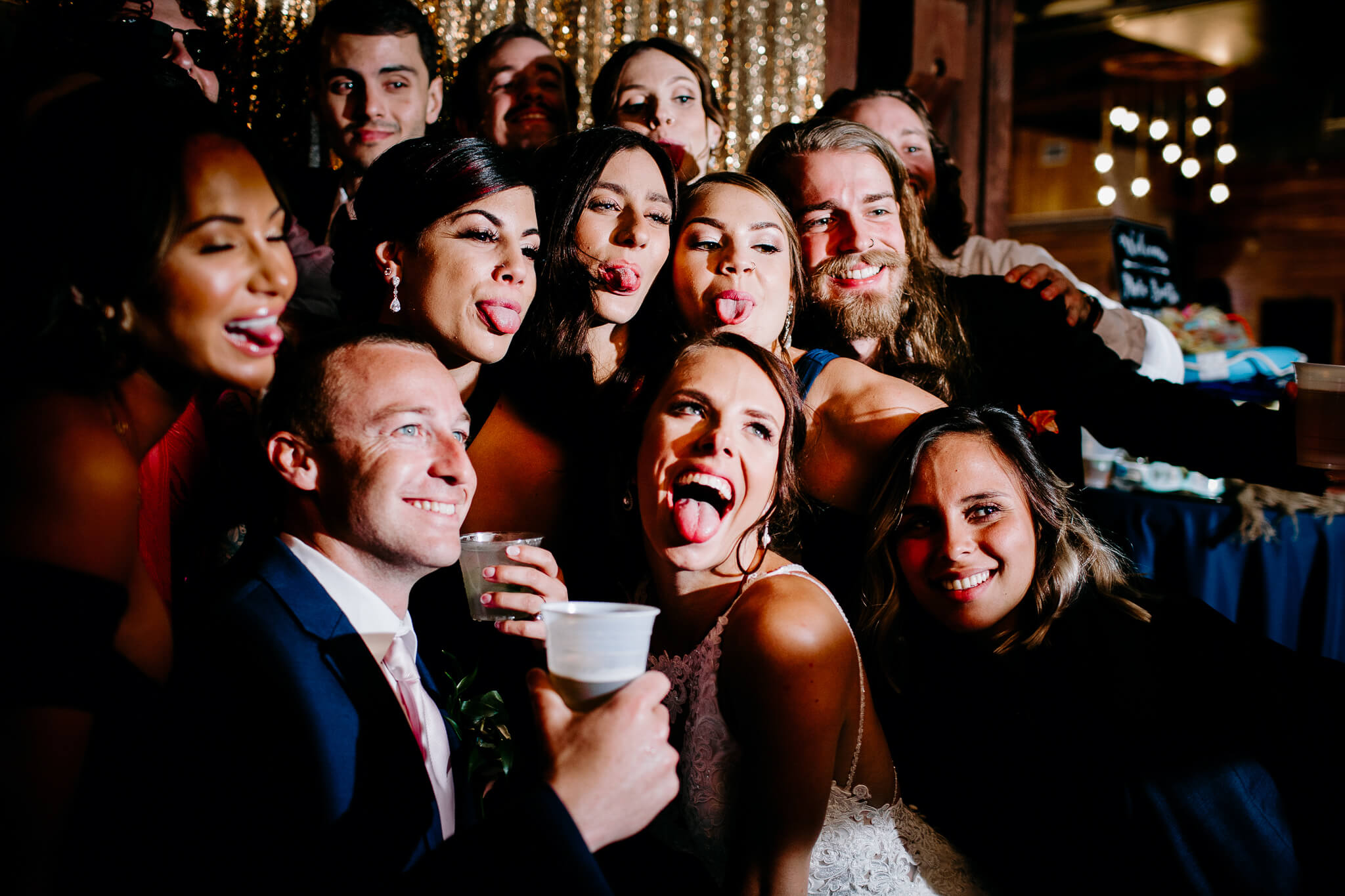 Bride and groom pose and make sill faces sticking their tongues out for the photobooth during their wedding at an outdoor wedding venue in Central FL