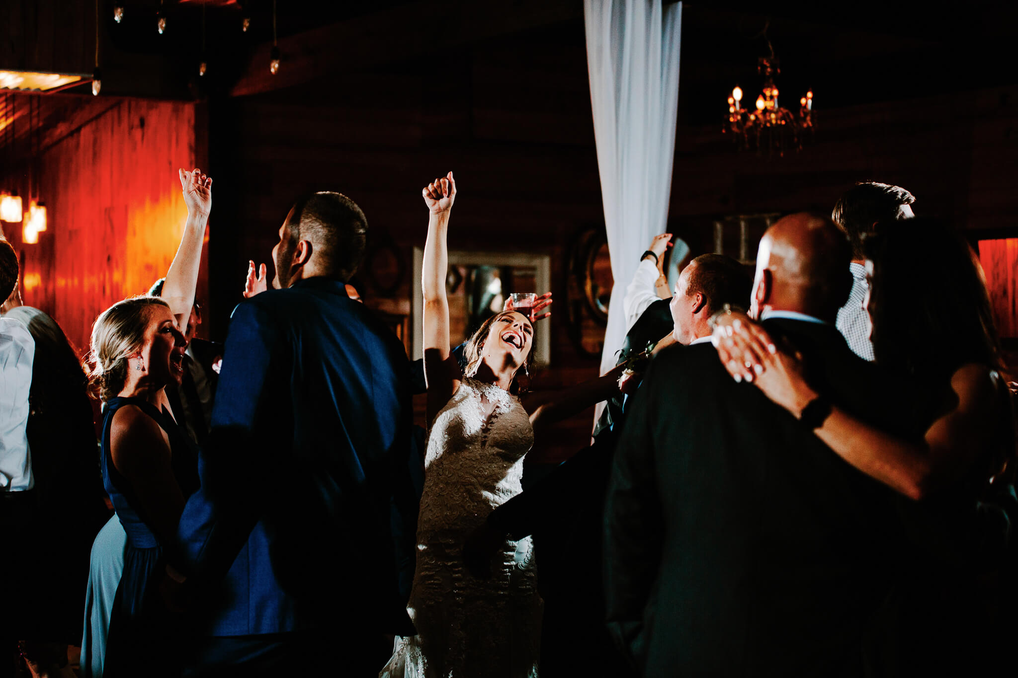 Bride raises her fist in the air to celebrate in the dance floor during wedding reception at an outdoor wedding venue in Central FL