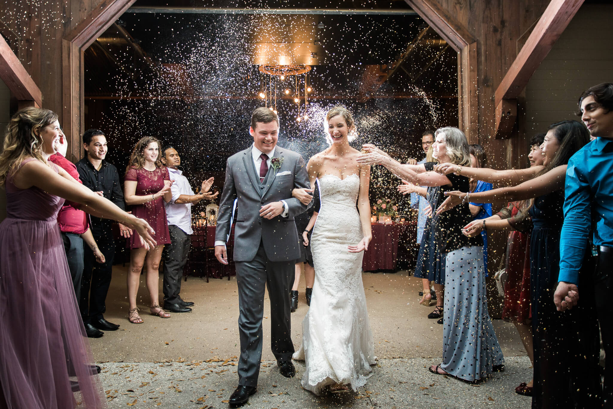 Wedding guests throw rice at bride and groom as they walk out Club Lake, an an outdoor wedding venue in Central FL