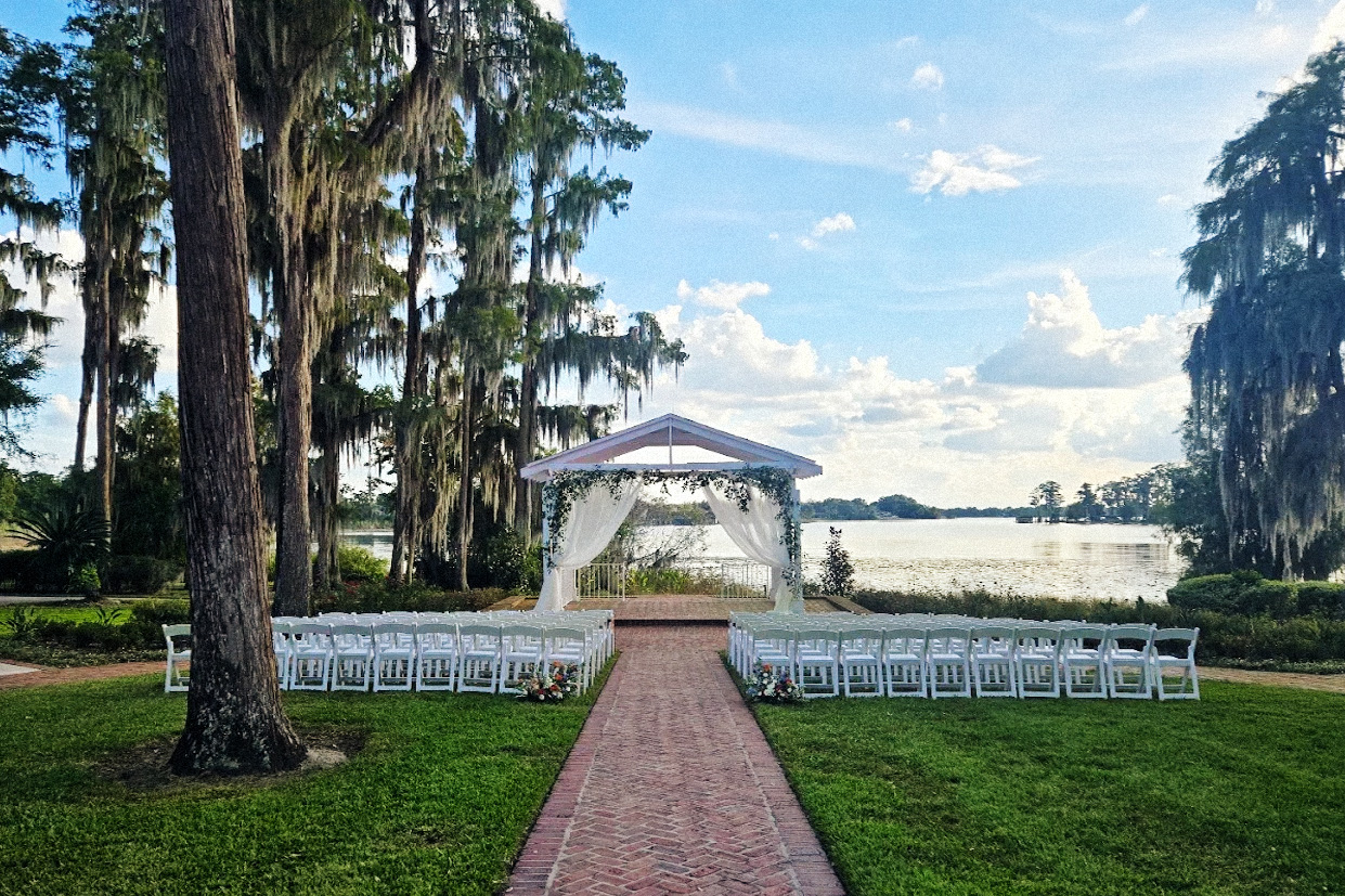 outdoor ceremony site with a lakeside backdrop under a blue sky with some clouds