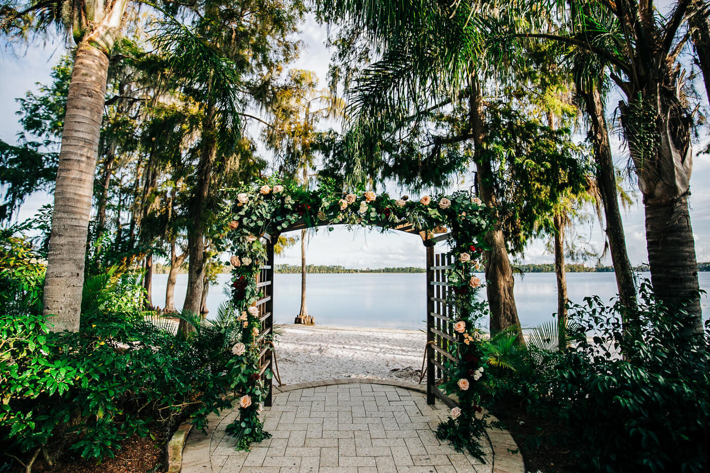 lakeside wedding ceremony site with palm trees at Florida wedding venue Paradise Cove