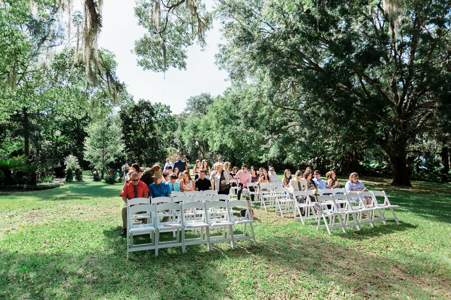chairs with guests at a wedding ceremony in a lush garden