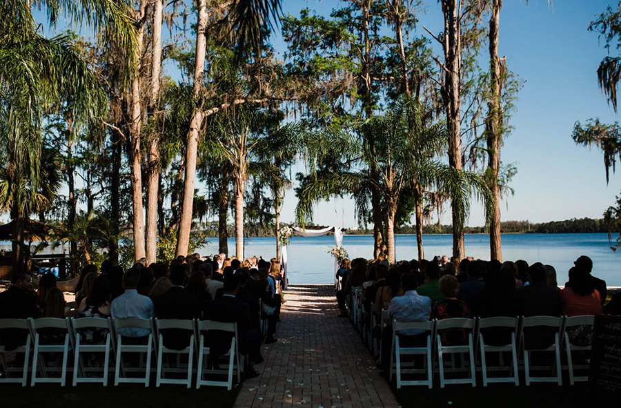 lakeside wedding ceremony site with tropical trees at Florida wedding venue Paradise Cove