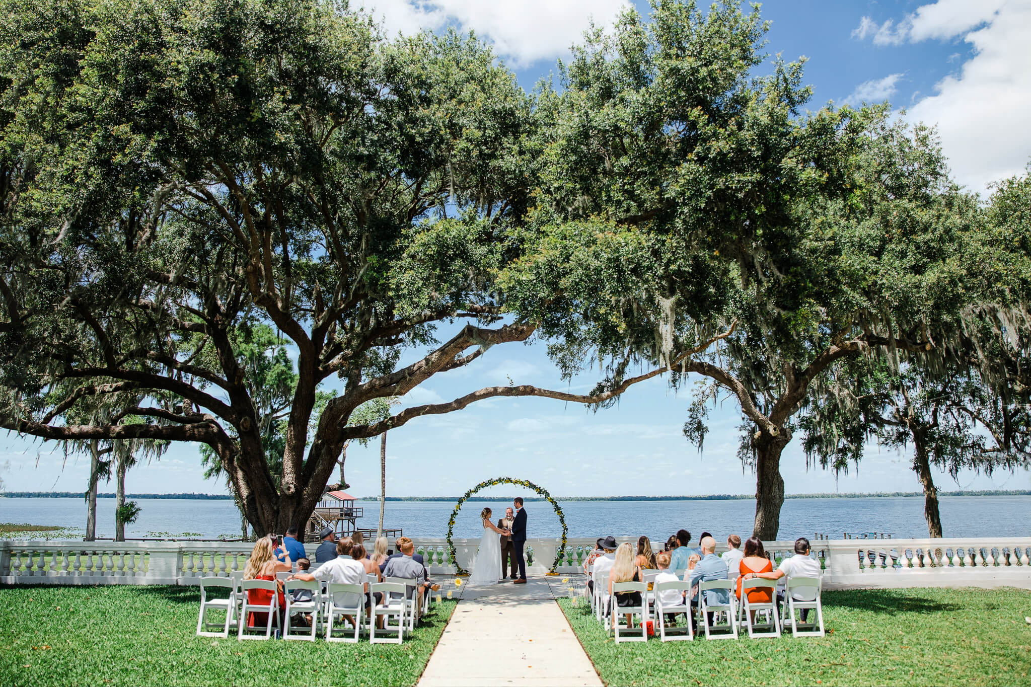 Florida wedding with ceremony with lakeside views under arching trees 