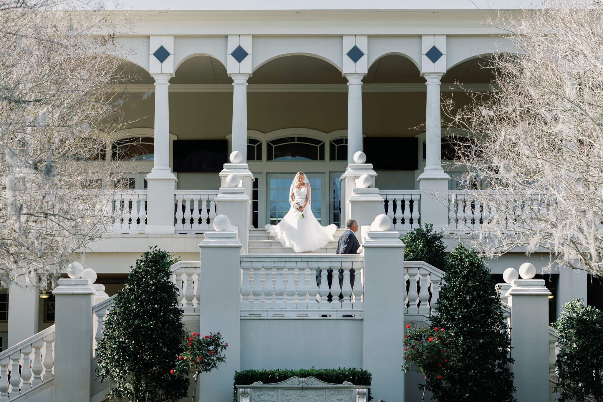 Bride walk down stairs on a modern elegant venue with columns