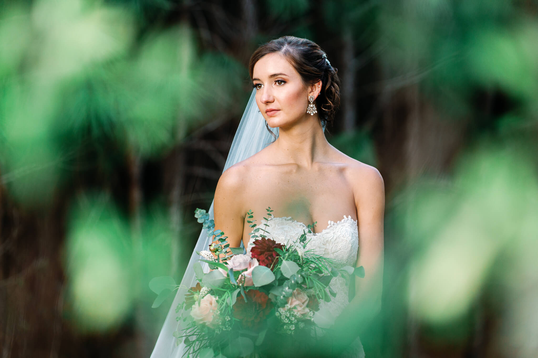 elegant bride poses for wedding portrait while holding flower bouquet