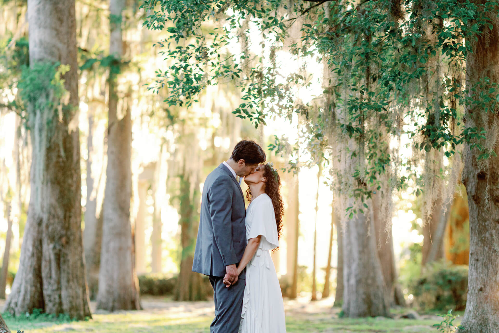 Bride and groom holding hands and kissing during elopement photos in Orlando