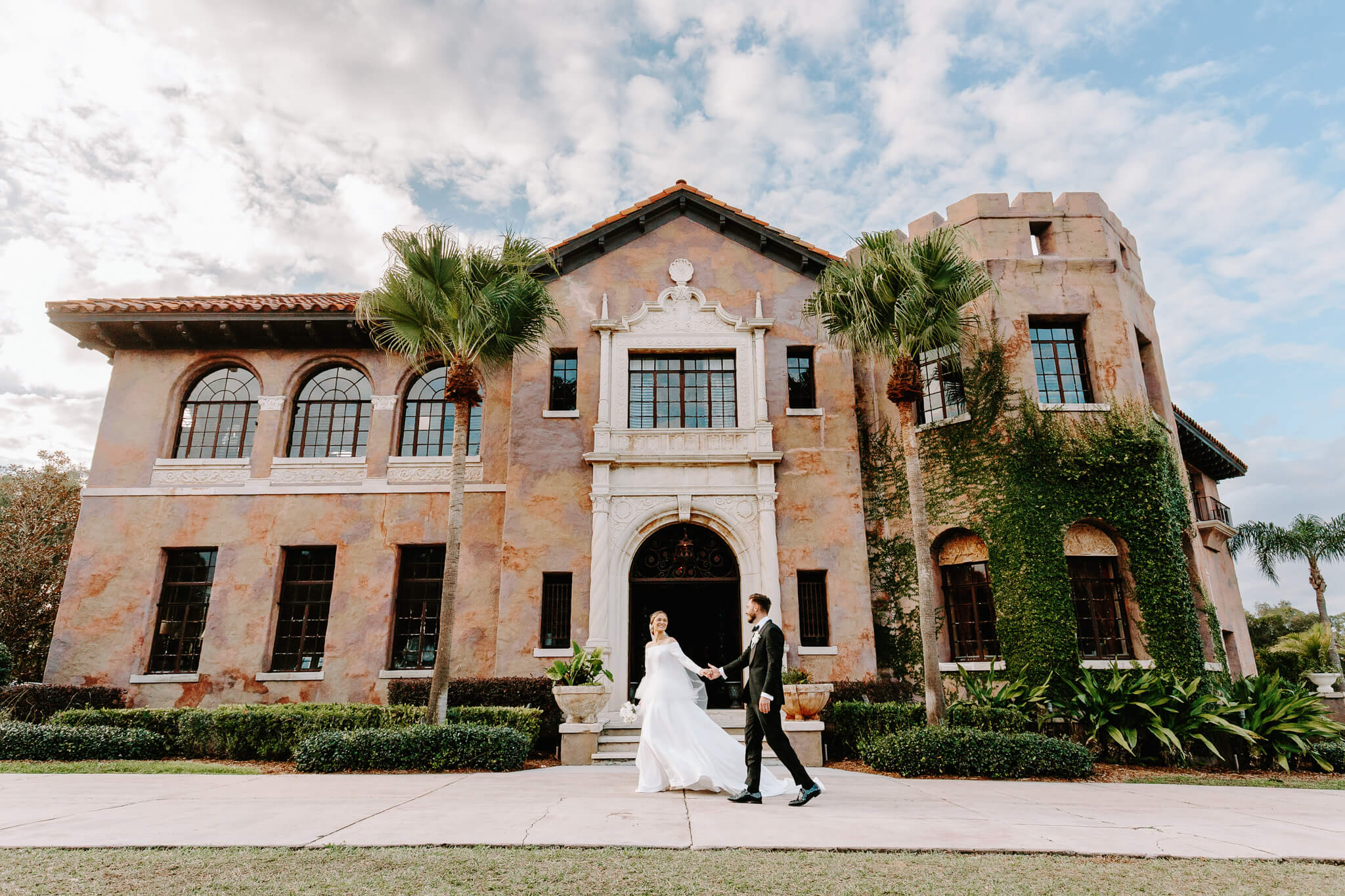 Bride and groom pose for portrait in front of the Howey Mansion, a estate mansion wedding venue in central Florida