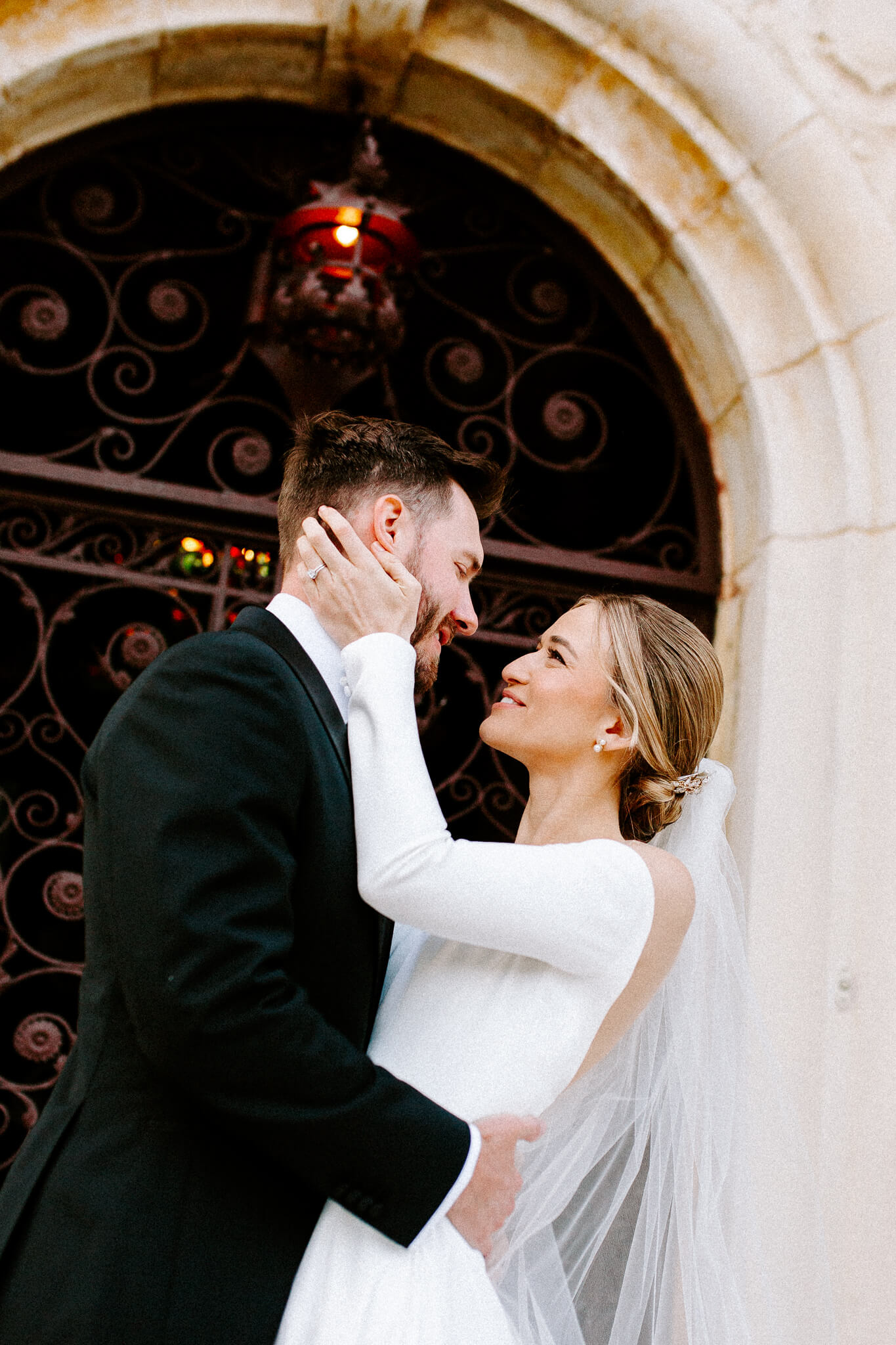 Wedding couple embraces each other and looks at each other with big smiles at the howey mansion