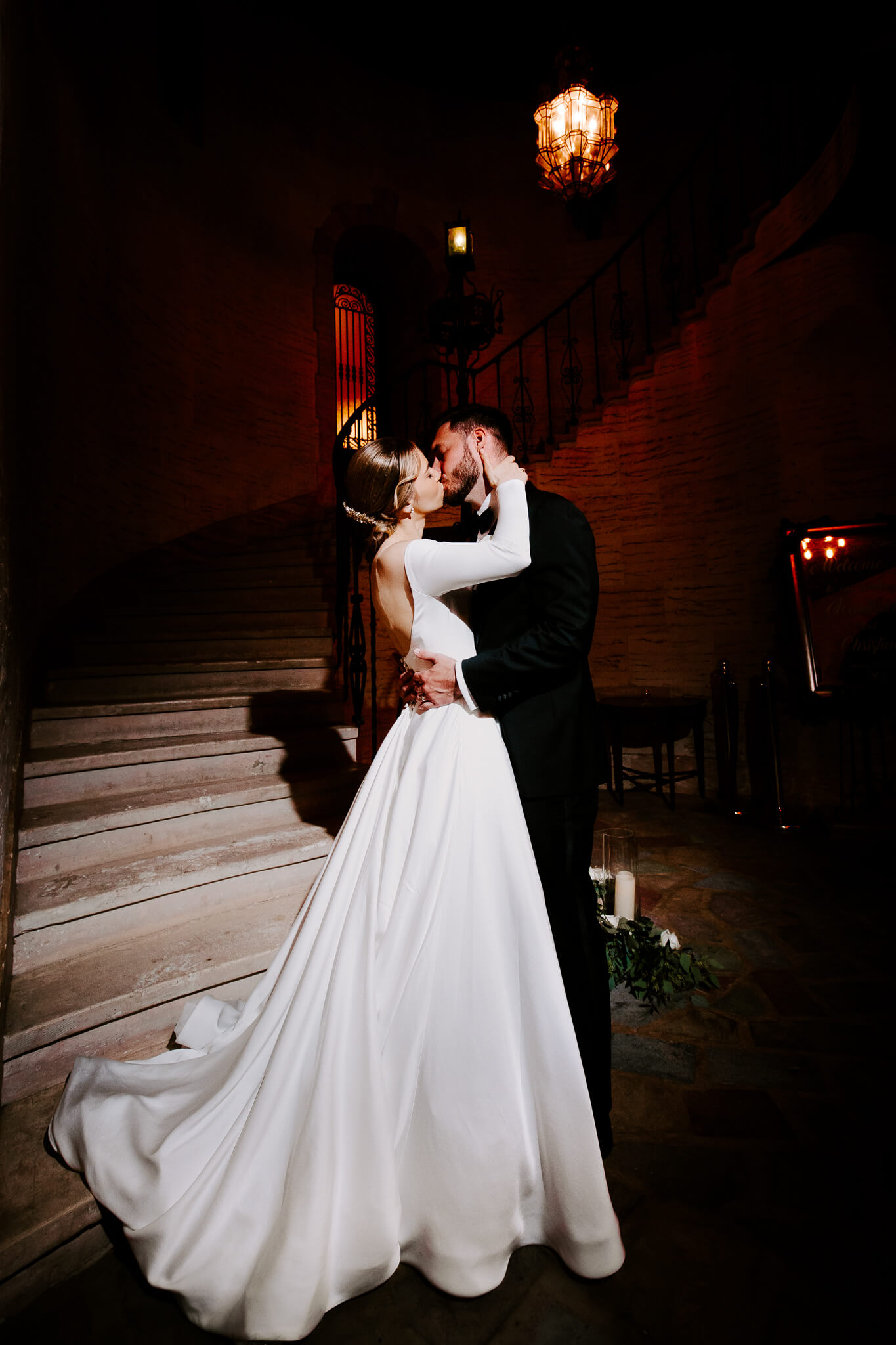 bride and groom pose in front of a grand staircase at The Howey Mansion