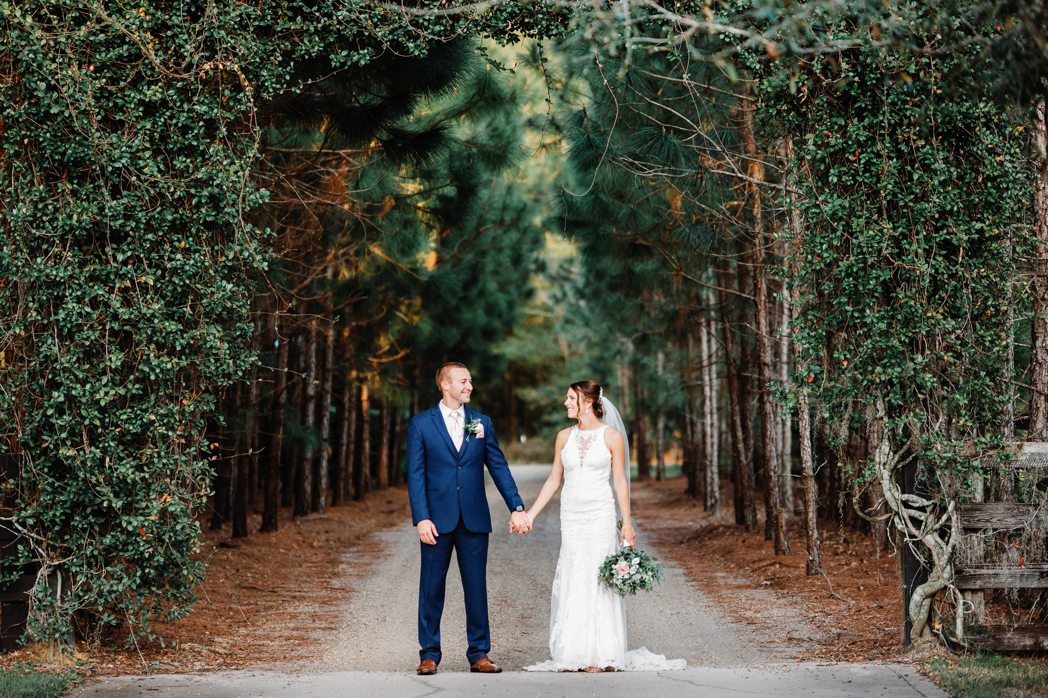 groom in blue suit holding hands with bride at Club Lake Venue
