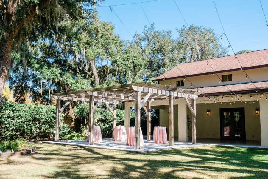 Tables set up with light pink linens for cocktail hour outdoors