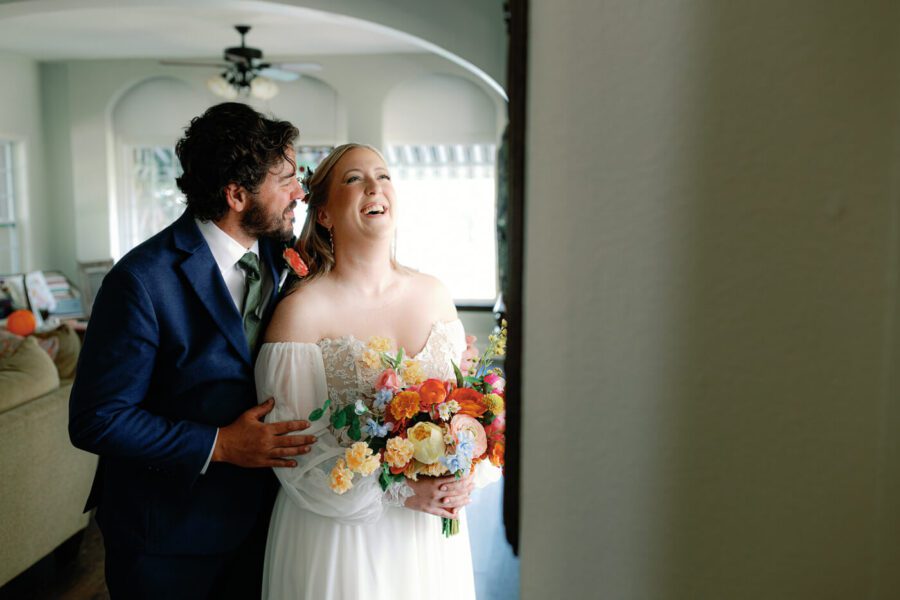 bride laughs with joy as groom leans closer to her
