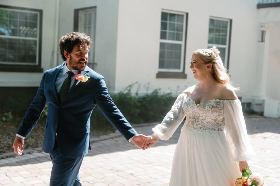 groom and bride hold hands while walking