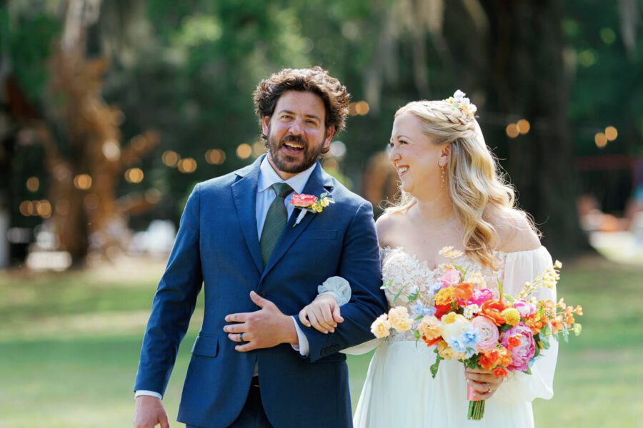 Wedding couple linking arms and smiling while posing for wedding photos at Lake Lucy Estate