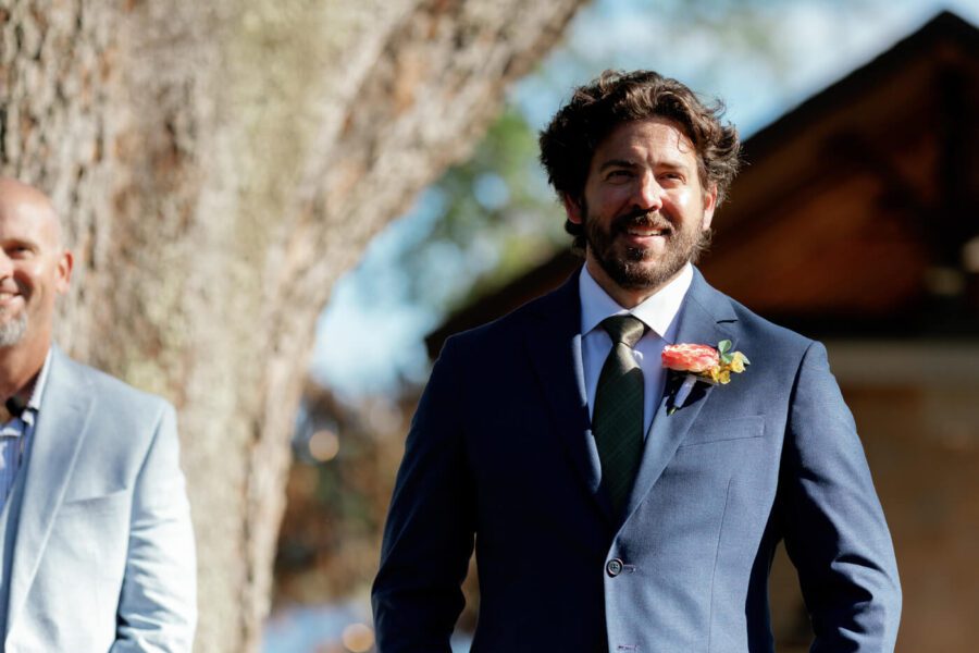groom smiling while waiting for bride to walk down the aisle