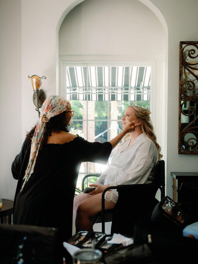 bride getting ready and having make up applied at Lake Lucy Estate