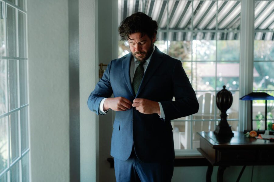 groom in blue suit adjusting his jacket