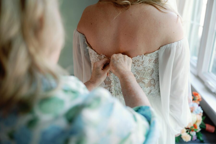 mother of the bride adjusting the wedding dress